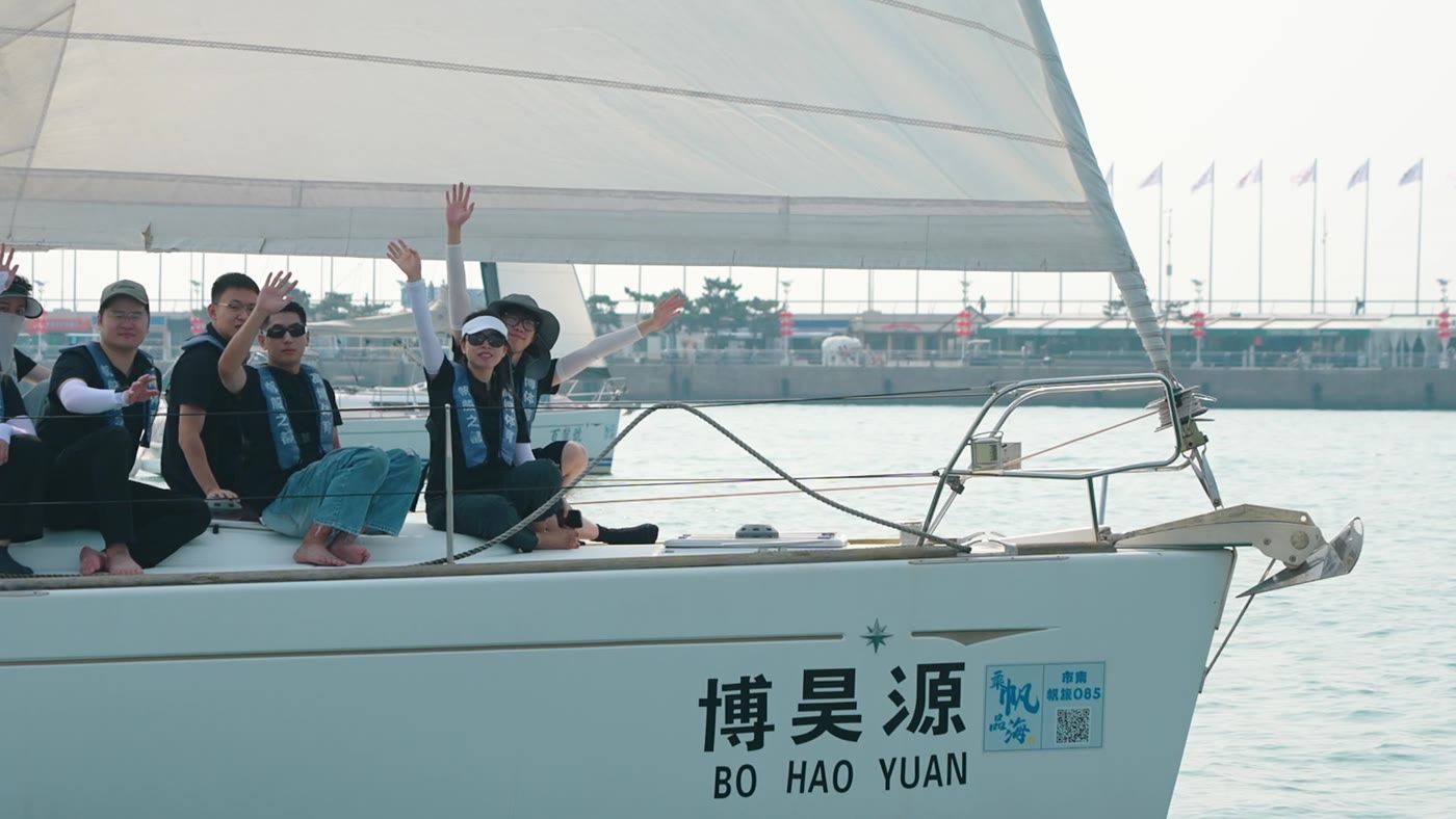 学员在帆船上向镜头招手